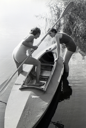 Two young women pulling a boat, Klepper T6 from the coast into the lake, Germany 1930s (b/w photo)