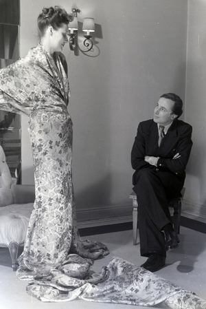 The fashion designer Heinz Schulze-Bibernell and a model trying a dress, Germany ca.1939 (b/w photo)