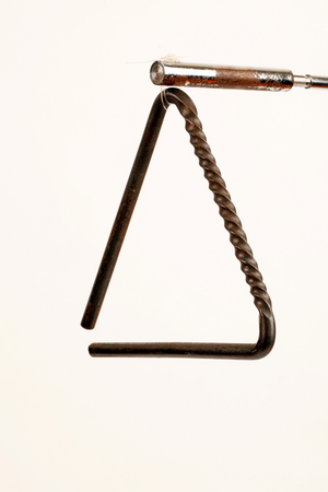 Triangle with a twisted construction to provide a serrated surface for scraping the beater along, as well as the traditional way to play it