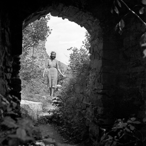 A young woman sightseeing the remains of an old castle, Austria 1930s (b/w photo)