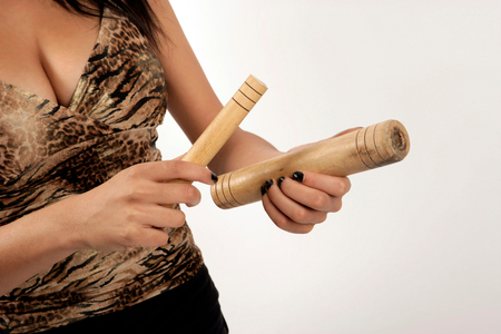 Young woman playing a pair of cuban claves