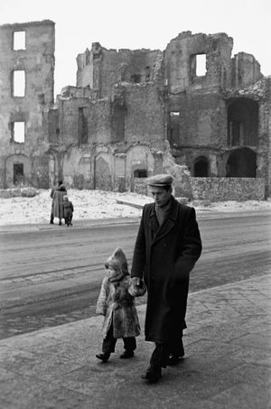Father and son walk past houses still in ruins 12 years after the end of World War II ..., 1957 (photo)