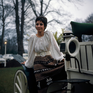 Israeli singer and actress Esther Ofarim poses in front of a white coach, circa 1969