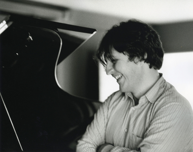 Thomas Adès standing beside piano, 2000 (photo)