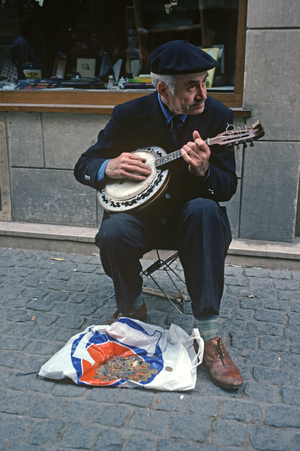 Street musician playing banjo in Paris, France (photo)