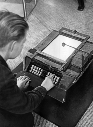 A boy writes on the first German typewriter, around the 1930s (b/w photo)