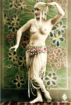 A semi-nude woman wearing a pearl cap and shorts with pearl strings attached, standing in front of a floral design, 1925 (tinted photo)