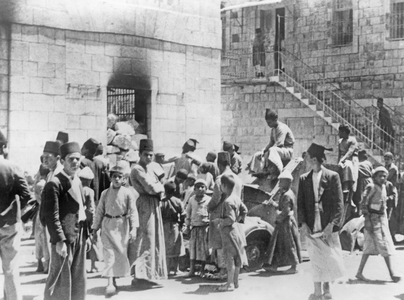 Children playing on a destroyed British armored car in Hebron, 1938 (b/w photo)