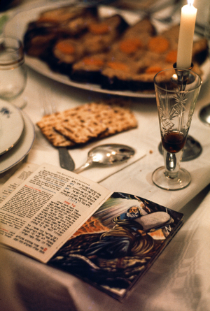 Photograph of a Passover siddur prayer book with a bible scene during the Passover Seder, 1974 (photo)