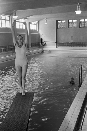 Young woman standing on the diving tower in a swimming pool, Freudenstadt, Germany 1930s (b/w photo)