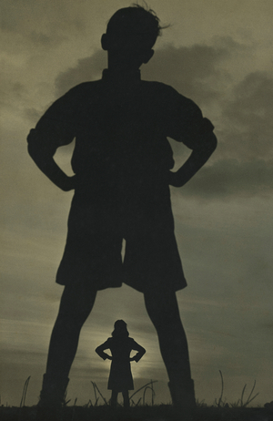 Sihouette of two kids standing outdoors.