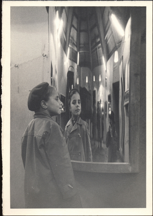 Kid looking into a distorting mirror, ca 1960 (photograph)