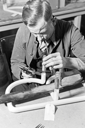 A staff member producing a fluorescent tube, Germany 1930s (b/w photo)
