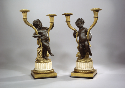 Two candelabra in the form of revelling putti, late 18th century (patinated & gilt bronze with Carrara marble socles)