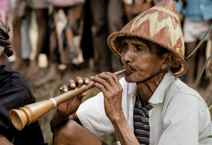 Man plays flute-like instrument, Probolingo, Java, 1970 (photo)