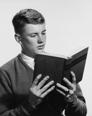 Close-up of a teenage boy reading a book