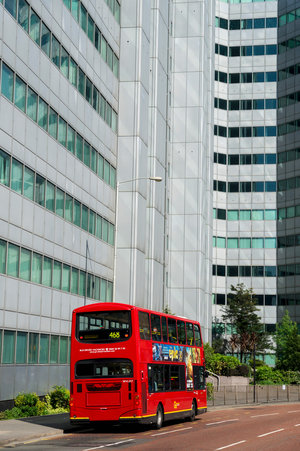 A red double decker bus on the street below an office building, Croydon, London, England, UK  (photo)