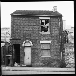 This site is unidentified but is likely to be around Middleport, Burslem or Hanley, A derelict house with industrial complex in the background, City Of Stoke-On-Trent, UK, 1965-68 (b/w photo)