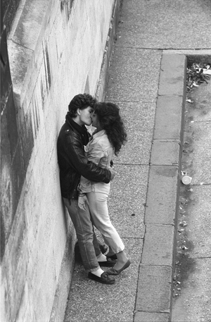 Couple kissing while leaning against wall in Paris, 1980s (photo)