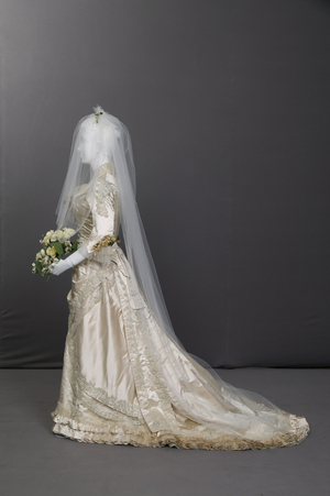 Wedding dress, 1880 (side view), Silk satin, lace, glass beads, net, wax flowers, Maker unknown