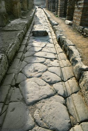 Street in Pompeii, paved with basalt slabs, bordered by high sidewalks