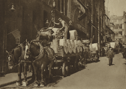 Hoisting in paper at a newspaper printers' (b/w photo)