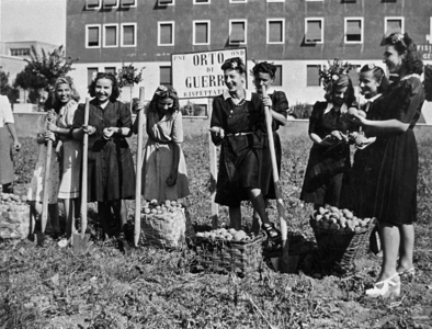 ITALY Ten young women armed with shovel, but with clothing and footwear decidedly unsuitable for work, pose smiling with the crop of potatoes torn to the city's ground to solve the problem food of the civilian population while men are at the front