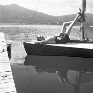 A young woman on a boat on the shore of a lake in the Wachau area, Germany 1930s (b/w photo)