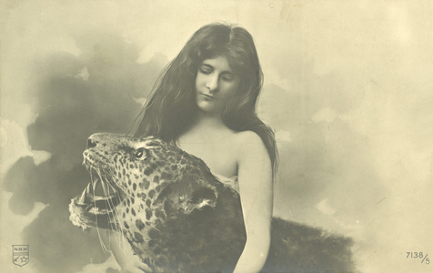 Long-haired girl with arms around stuffed leopard (b/w photo)