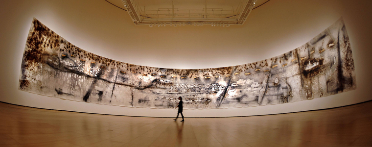 A visitor passes a gunpowder drawing of Chinese born artist Cai Guoqiang in an exhibition held in B