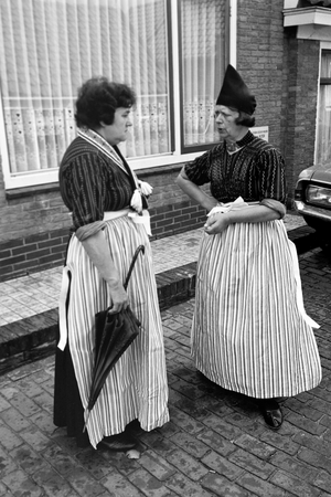 Two women wearing typical array chatting in a street of Volendam, The Netherlands 1971