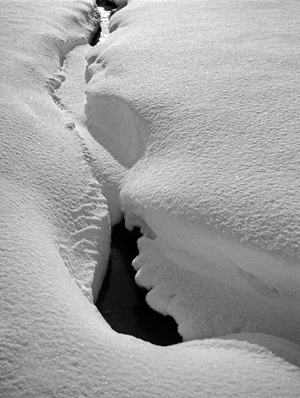 Snow covered creek in wintertime in East Prussia, 1930s (b/w photo)