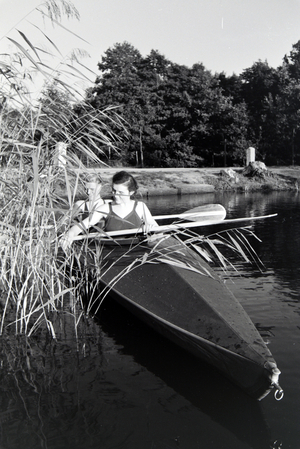 Young couple paddling in a boat on a lake near the river, Germany 1930s (b/w photo)