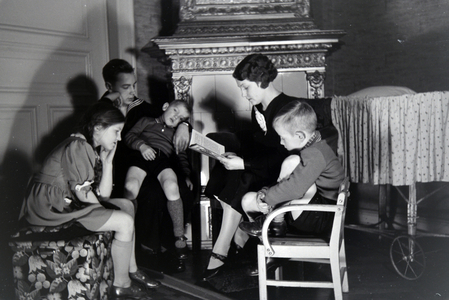 Members of an extended family reading a book together, Germany 1930s (b/w photo)