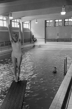 Young woman standing on the diving tower in a swimming pool, Freudenstadt, Germany 1930s (b/w photo)