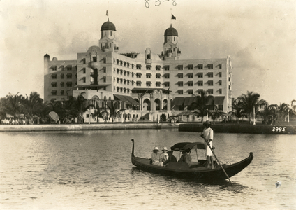 An Italian gondola, poled by an African American, takes visitors past the Nautilus Hotel, February 25, 1924 (b/w photo)
