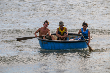 Vietnamese transport: Three men in a coracle, Mui Ne, Vietnam
