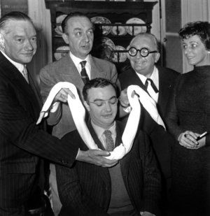 The “U Prize” Awarded to Francois Billedoux For His Piece “Tchintchin” Here Following Tradition A U-Shaped Towel Pass To The Neck Of Francois Billedoux By The Members Of The Jury From Left To Right Pierre Descaves Yves Bonnat And Marcel Achard Under The Look Of Katharina Renn Main Interpreter Of The Piece November 5, 1959 (b/w photo)