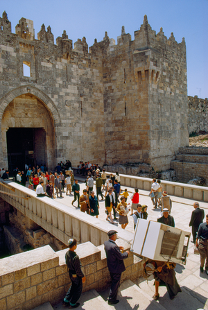 Pedestrians funnel through tall arched stone entrance Damascus Gate of walled city...., 1967 (photo)