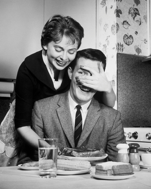 Mid adult woman covering eyes of mid adult man