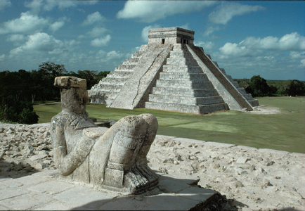 The figure of a Chac-Mool, ready to receive the hearts of victims of human sacrifice, gazes at Kukulcan Pyramid at Chichen Itza, Yutacan
