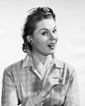 Portrait of a young woman pointing upwards