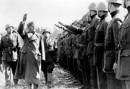 Benito Mussolini and Field Marshal Rodolfo Graziani (right, behind Mussolini) visiting Italian units at a military training area, April 1944 (b/w photo)