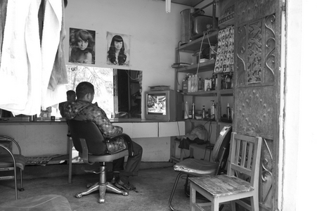 Man watching TV Deqin district. Yunnan, China (b/w photo)