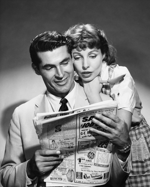 Young couple reading a newspaper