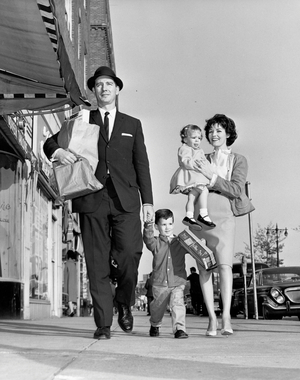Mid adult couple with their children walking on the sidewalk