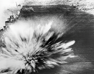 A Japanese bomb explodes on the flight deck of the USS Enterprise, killing the photographer, Phom 3/c Robert Read, but the film survived. (b/w photo)
