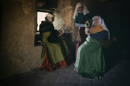 Hypothesis reconstructive military civilian life under the Lordship of the Scaligeri, fourteenth century: The Lady of the castle (sitting on the savonarola) with the two ladies, Castle of San Martino della Vaneza,, Fossona of Cervarese Santa Croce, Padua, Italy (photo)