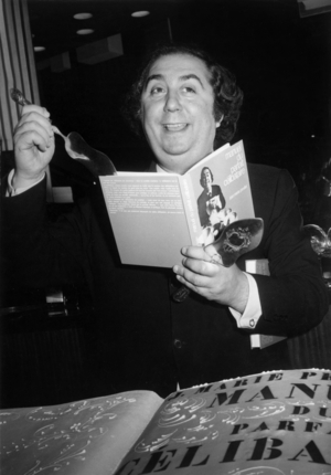 On The Scene Of The Olympia Jean Marie Proslier And His “Manual Of The Perfect Celibatiare” In Front Of His Bapteme Cake On October 9, 1968 (b/w photo)