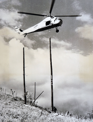 A helicopter being used to aid the construction of a building